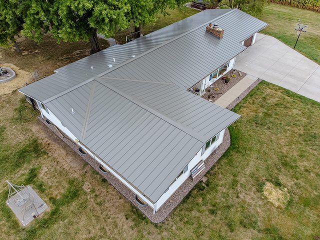 Aerial view of a finished low-pitch metal roof on a single-family house