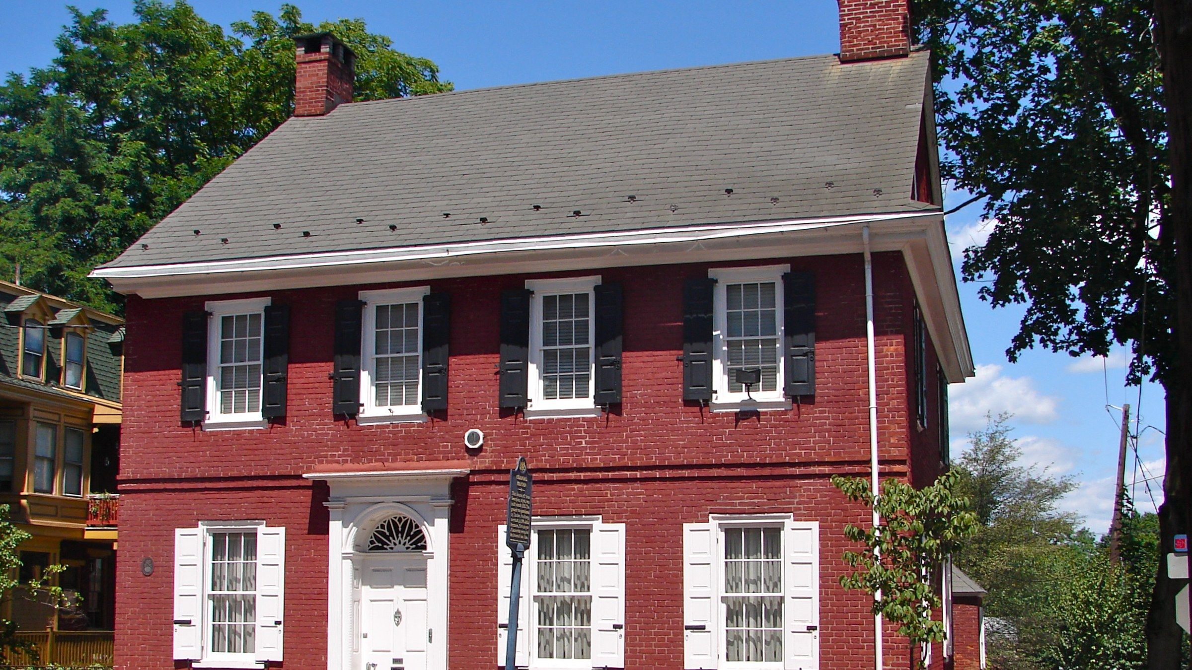 A brick colonial home in Northern Virginia with a clean gabled roof and white trim